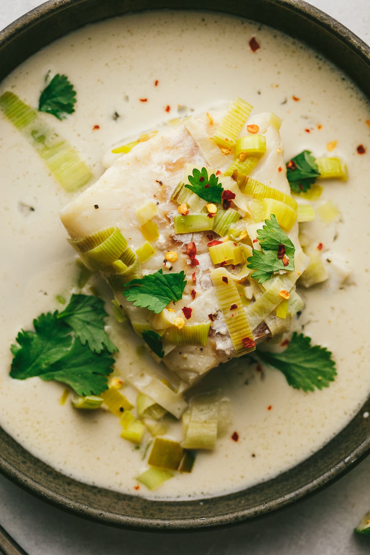 Cod in coconut milk with garnishes.