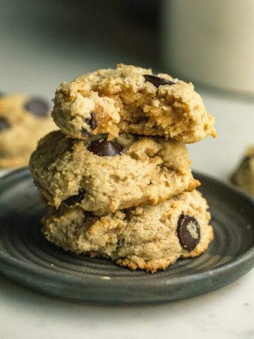 A stack of keto tahini cookies on a dark brown plate.