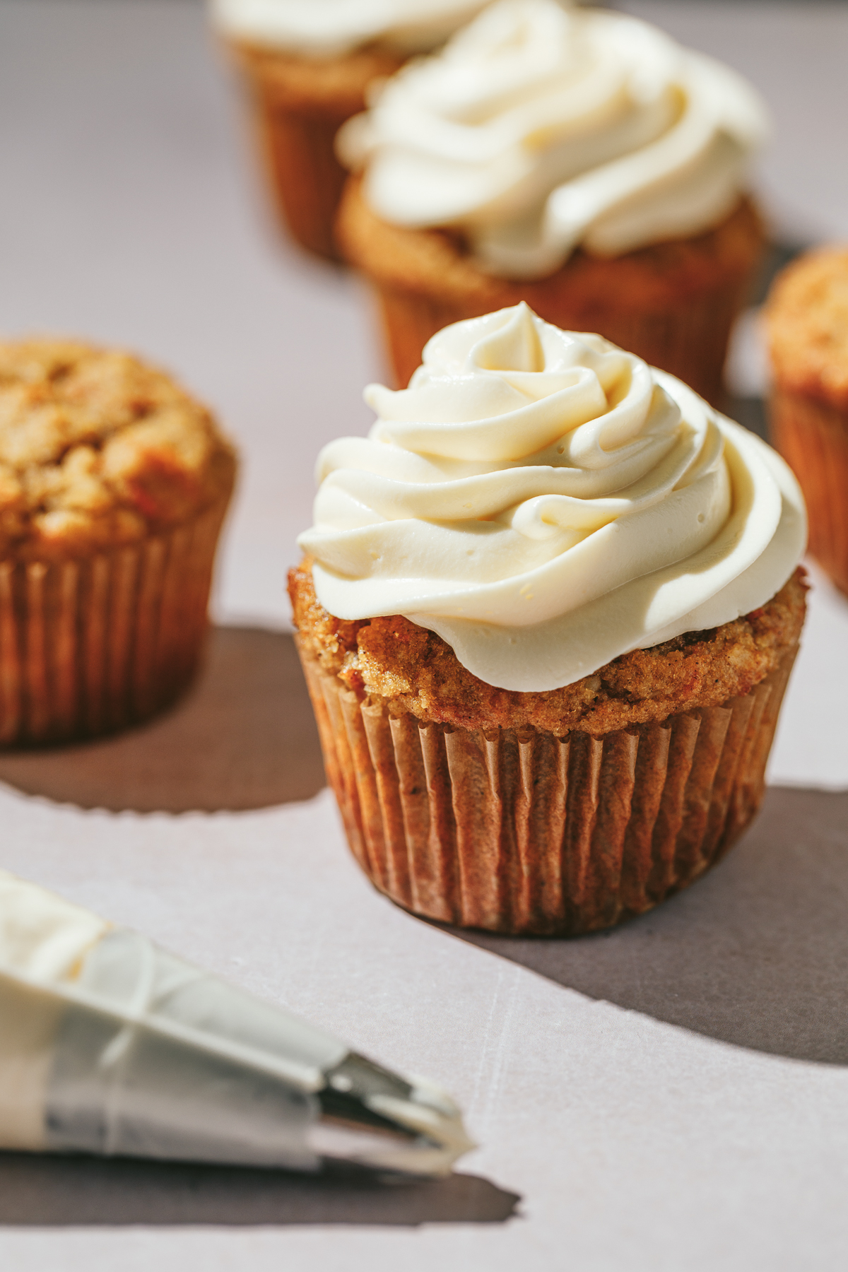 A keto carrot cake cupcake frosted with cream cheese frosting.