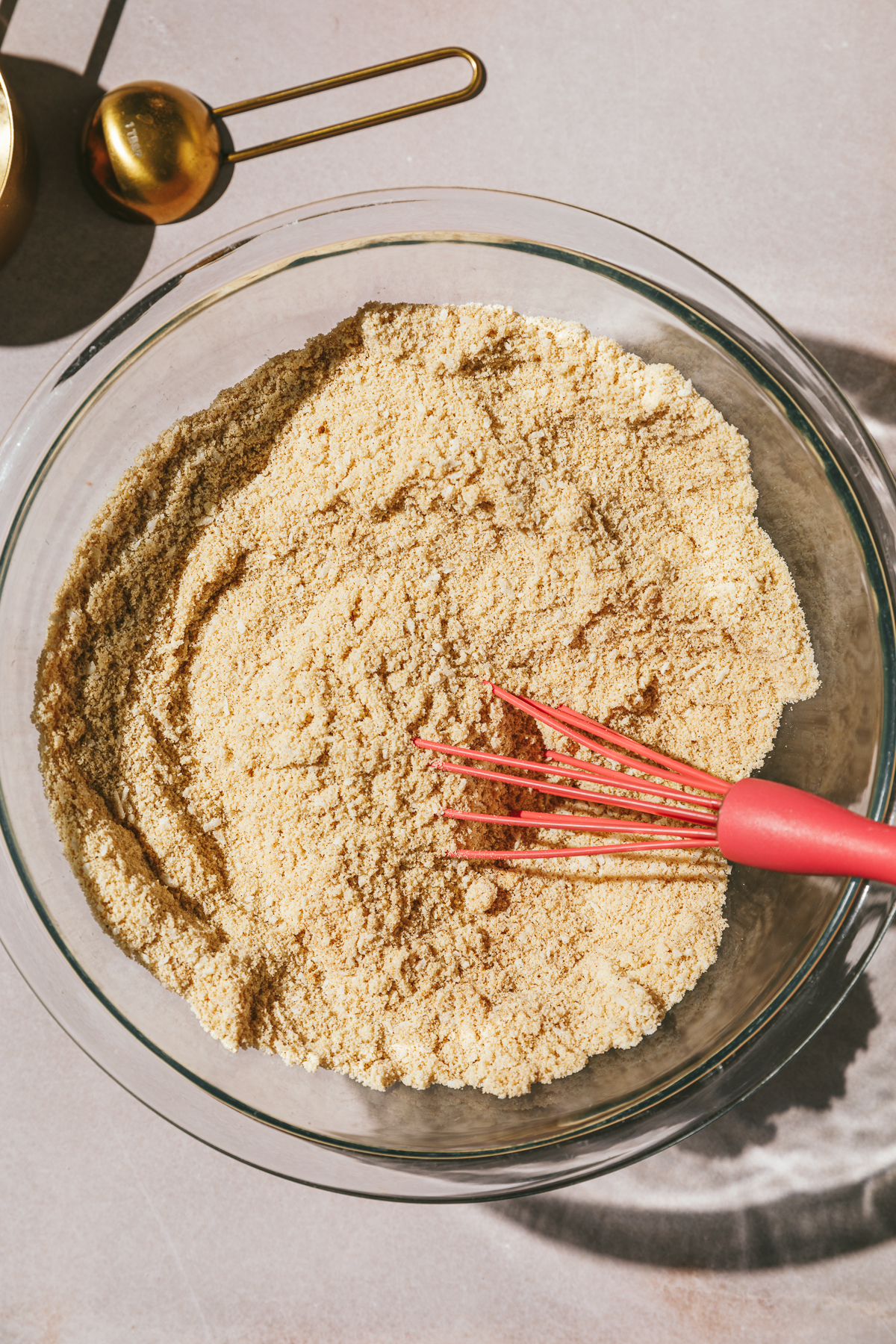 Dry ingredients in a glass mixing bowl for keto carrot cake cupcake recipe.