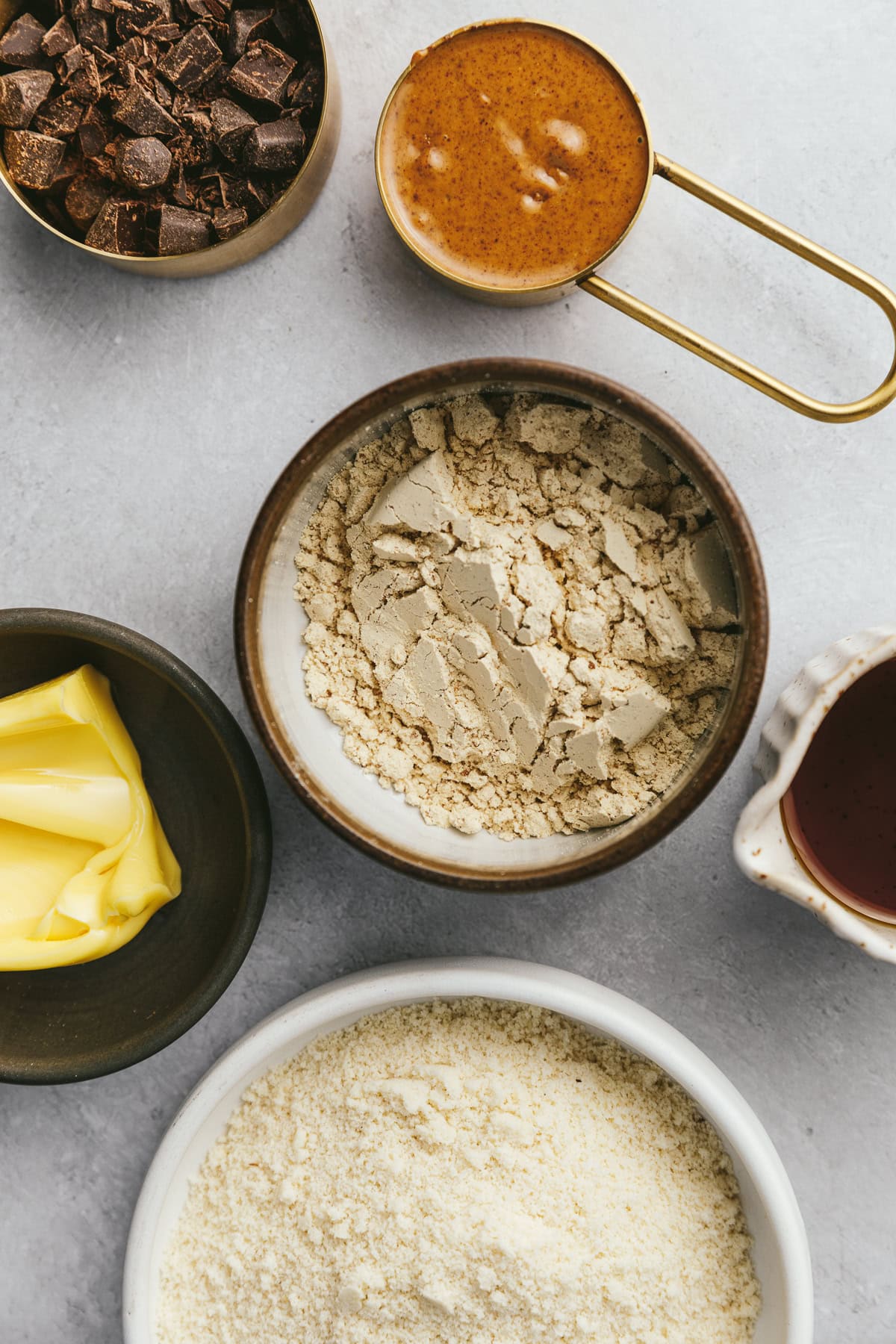 Ingredients for cookie dough protein balls on a gray marble surface.