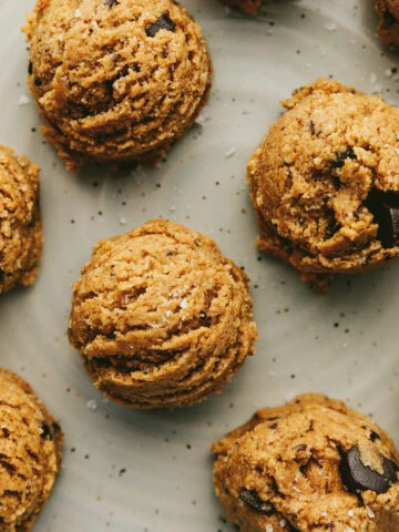 Closeup of the tops of cookie dough protein balls on a plate.