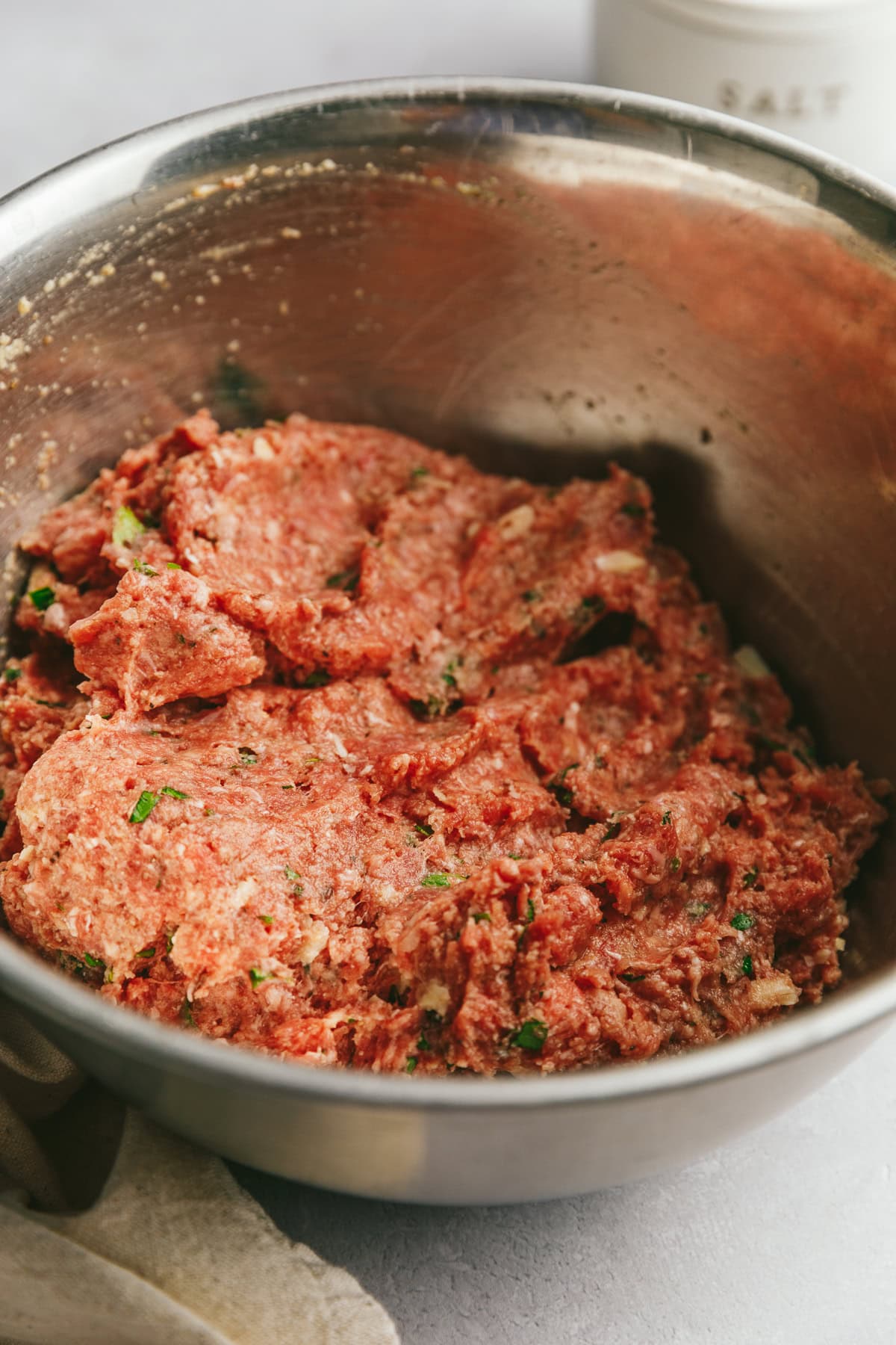 Meat mixture in a stainless steel bowl for keto Italian meatballs.