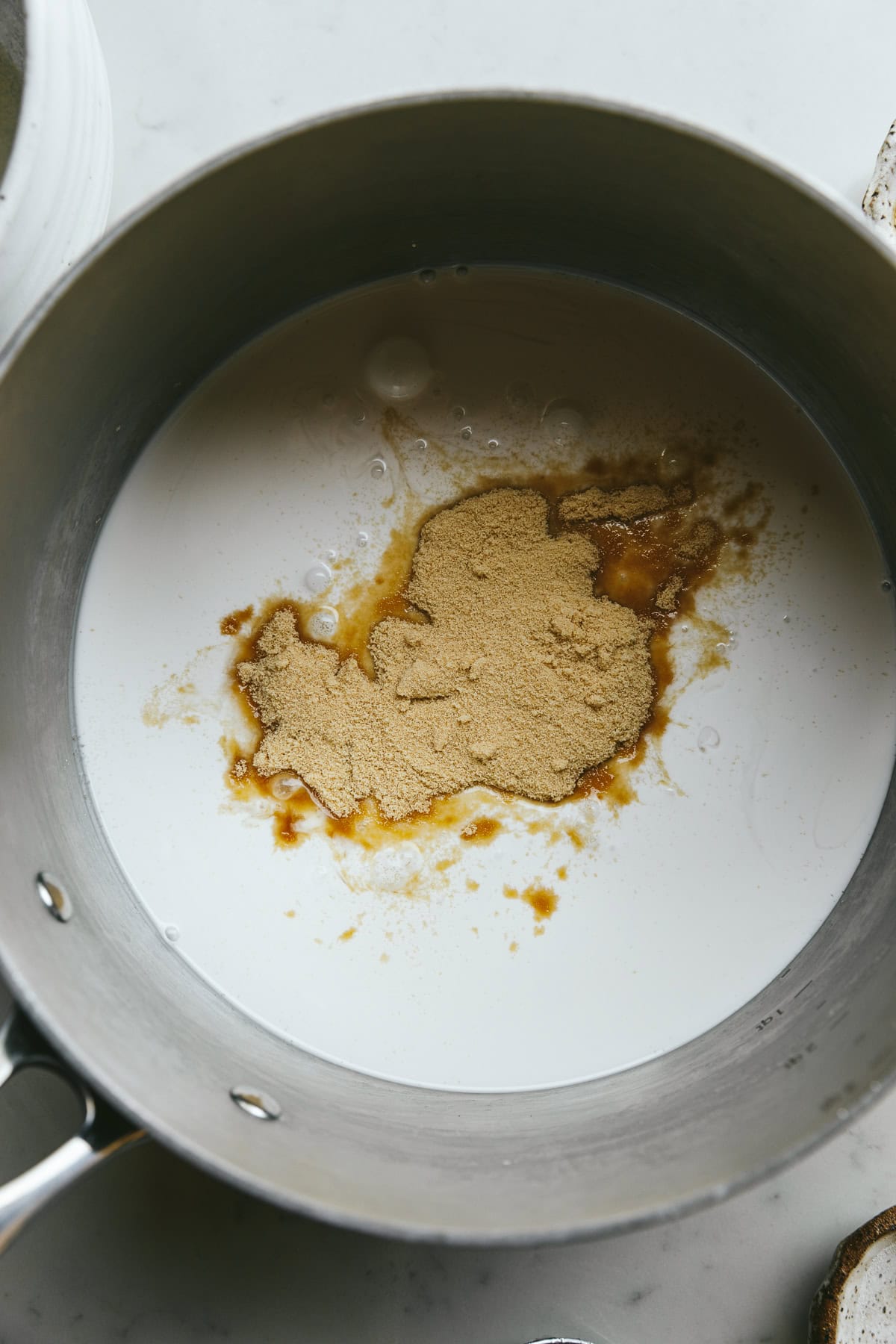 Granulated low-carb sweetener in a saucepan with coconut milk.