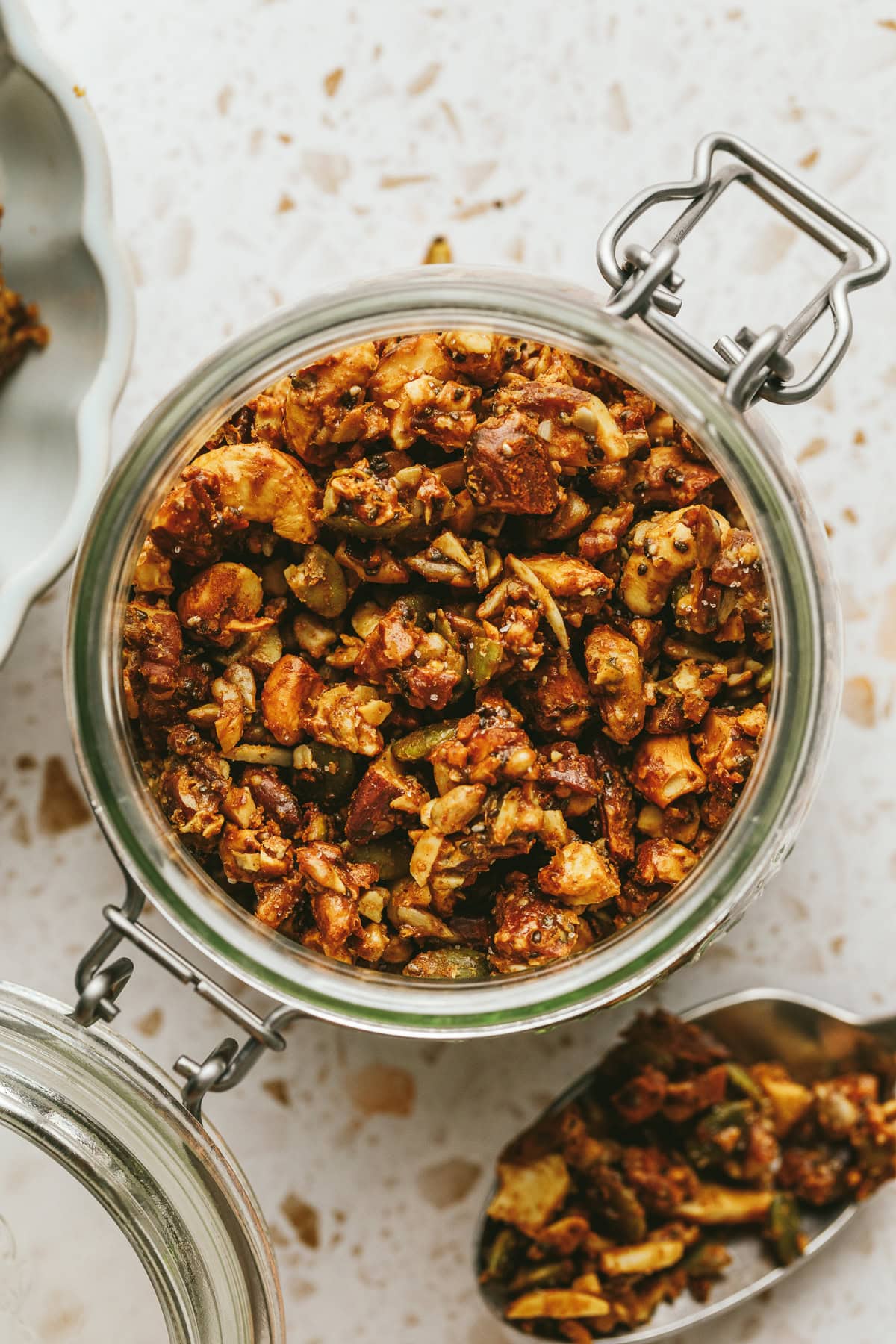 Closeup of a glass jar filled with grain-free vanilla almond butter granola.