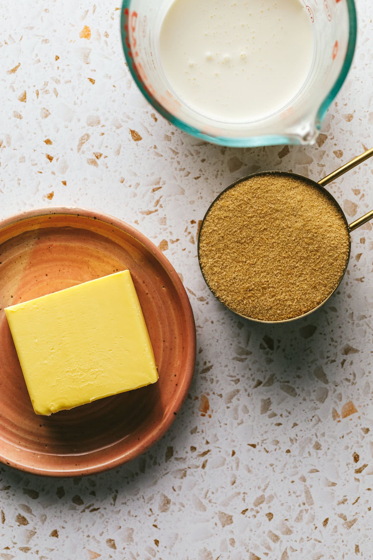 Ingredients for keto caramels on a speckled countertop.