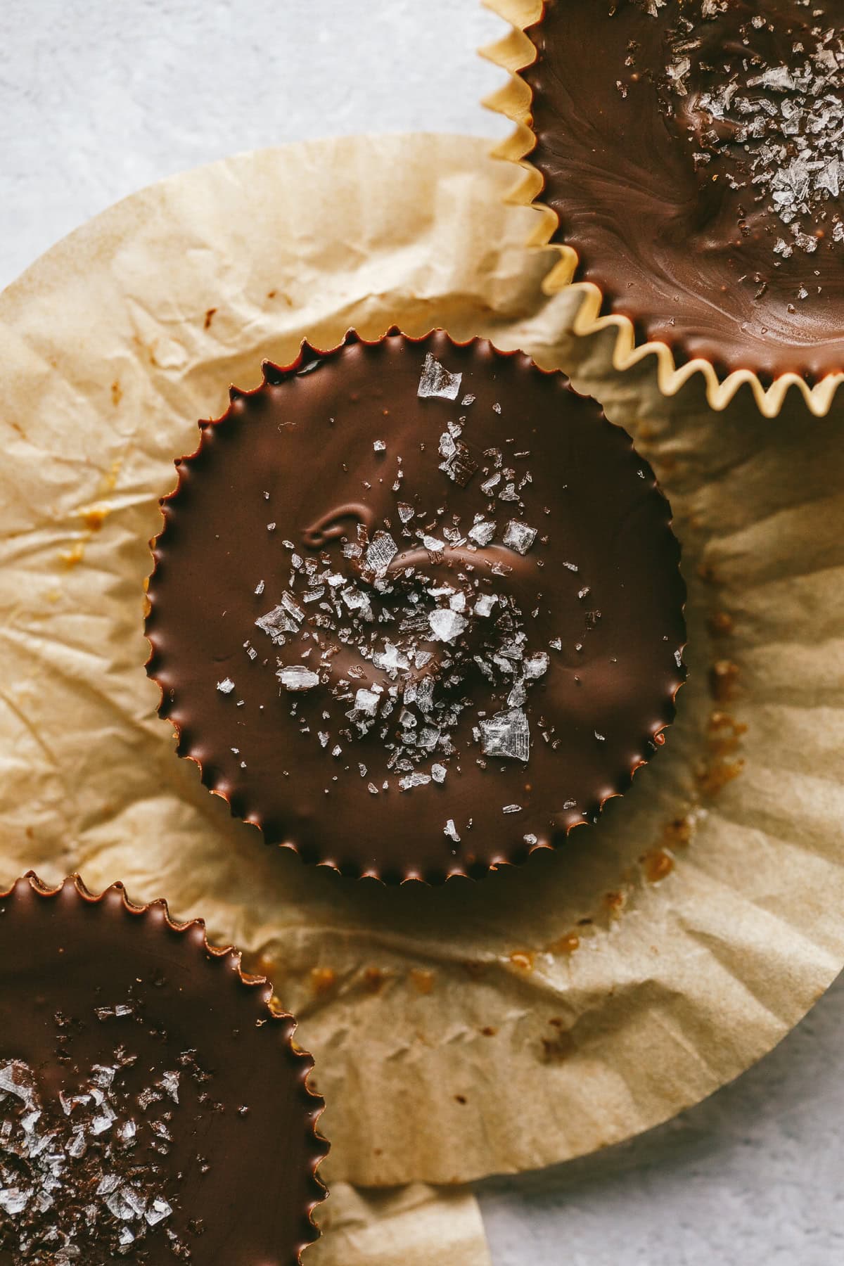 Dark chocolate almond butter cups with parchment paper.