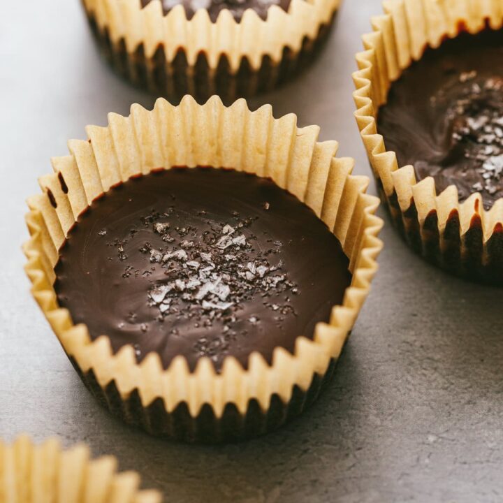 Closeup of keto dark chocolate almond butter cups in parchment paper cups.