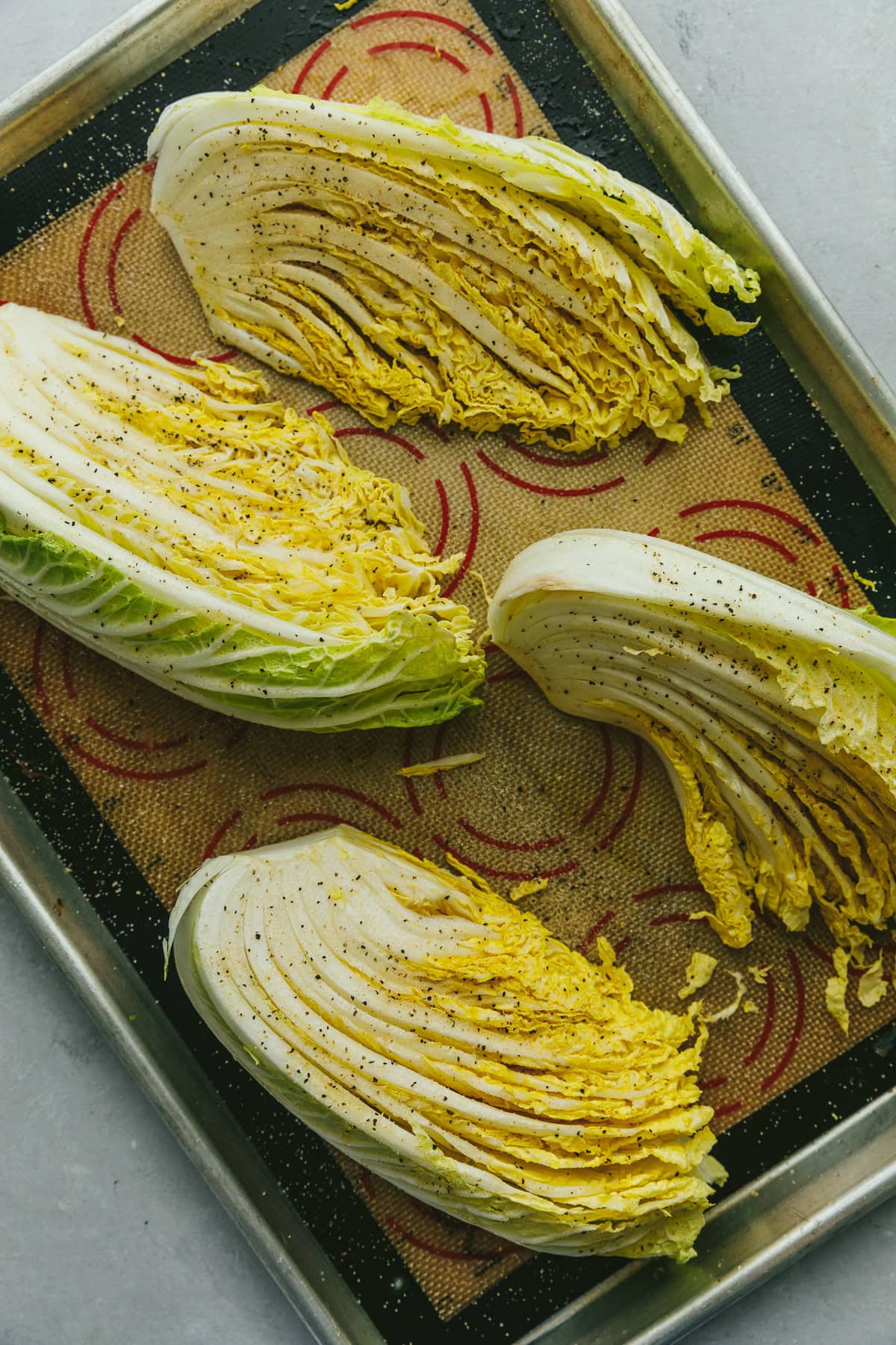 Napa cabbage wedges on a baking tray ready for roasting.