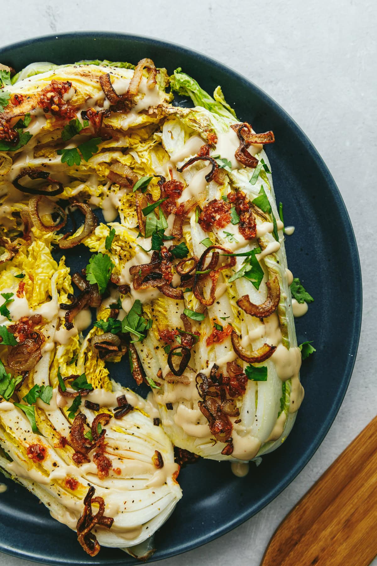 Roasted napa cabbage on a blue serving plate.