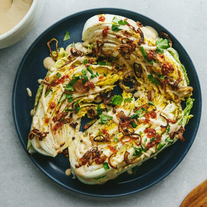 A blue plate with wedges of roasted napa cabbage.