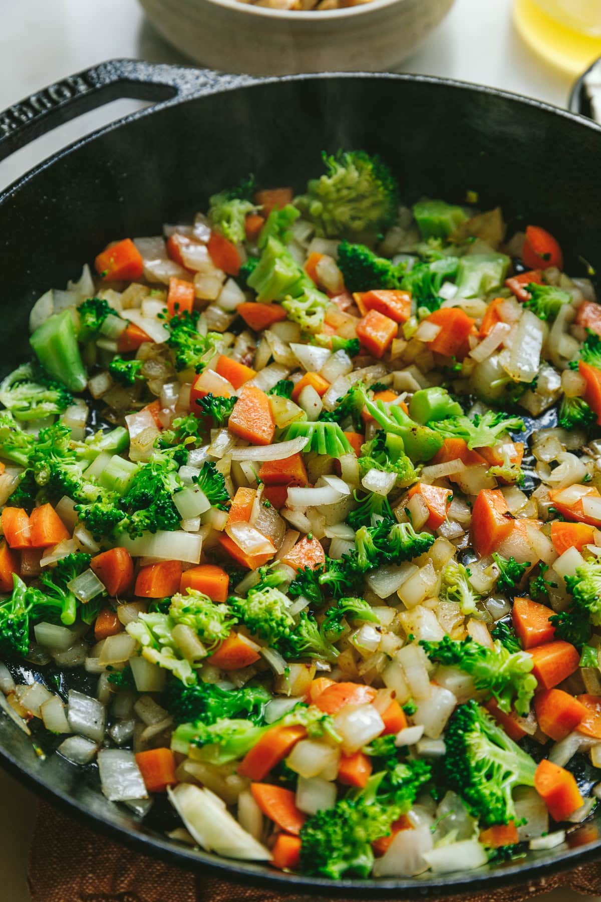 Cooking veggies in a black cast iron skillet.