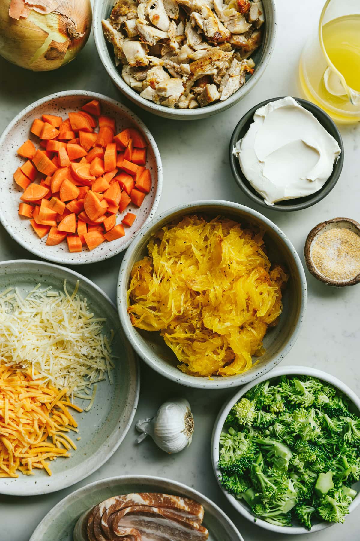 Ingredients for alfredo chicken and broccoli bake in small bowls.