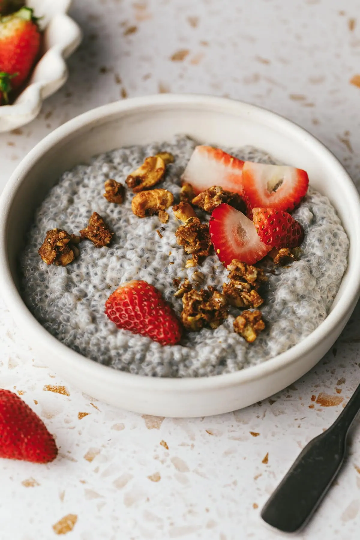 A bowl of basil seed pudding with toppings.