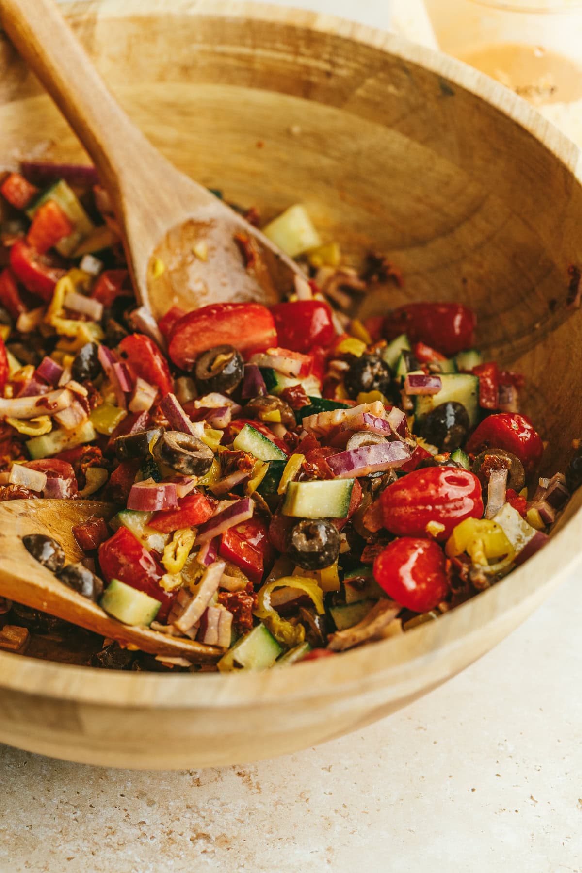 Closeup of wooden bowl with pizza salad ingredients.