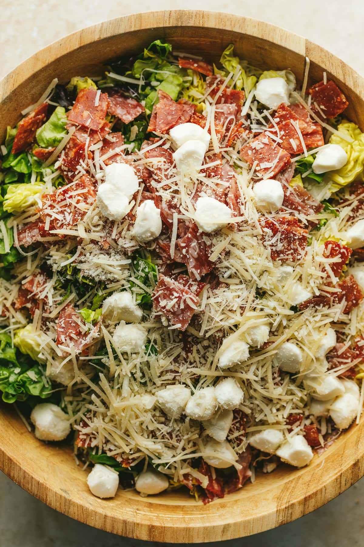 Adding the cheese and pepperoni to the pizza salad.