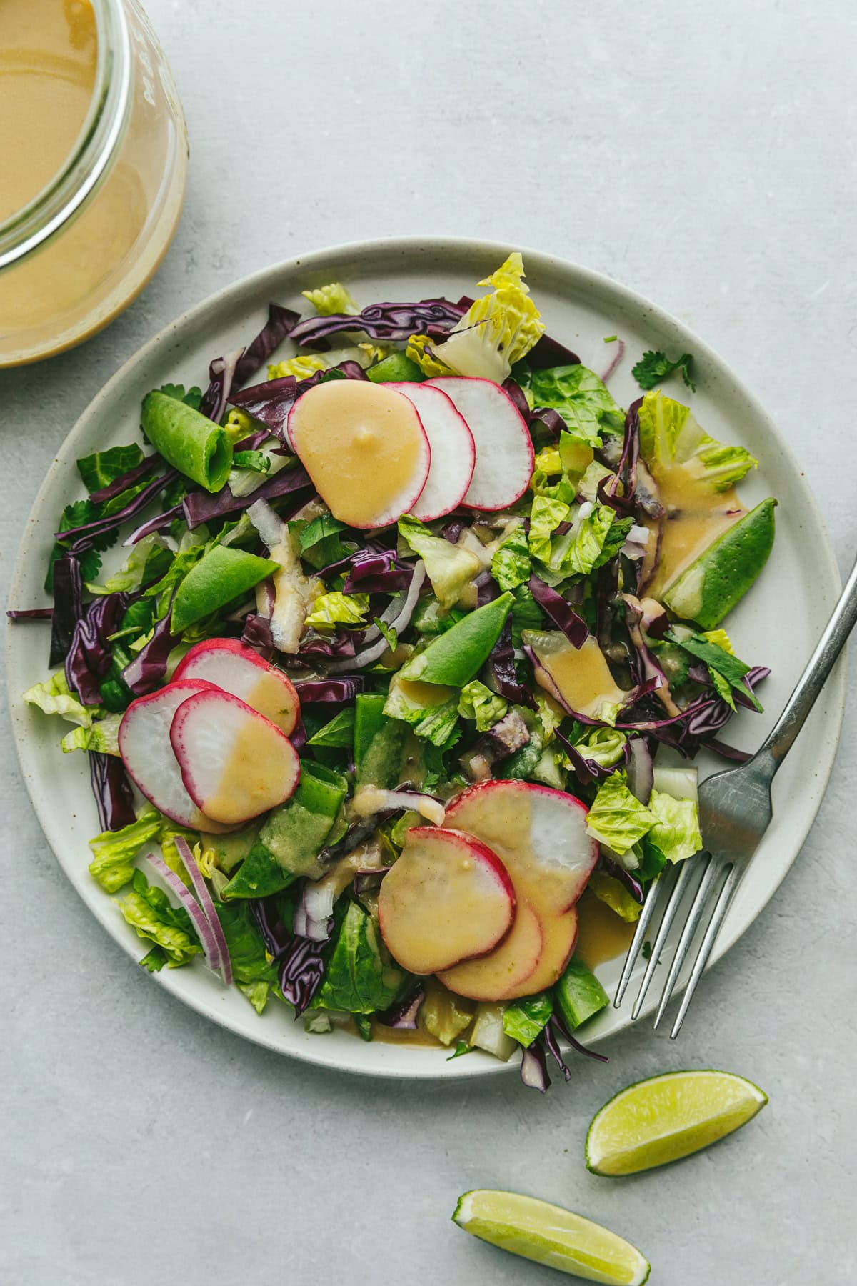 A salad topped with lime tahini dressing.
