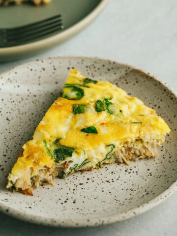A slice of crab frittata on a serving plate.