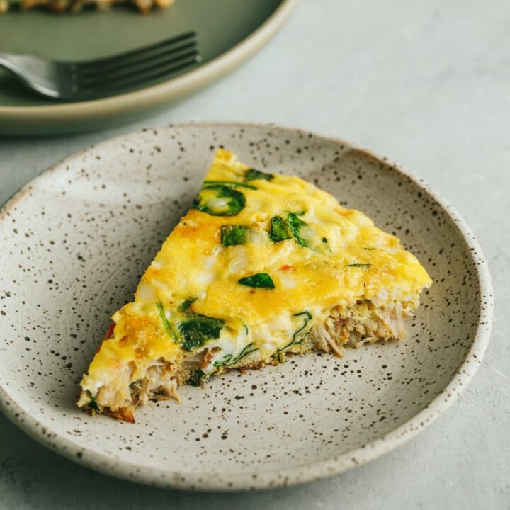 A slice of crab frittata on a serving plate.