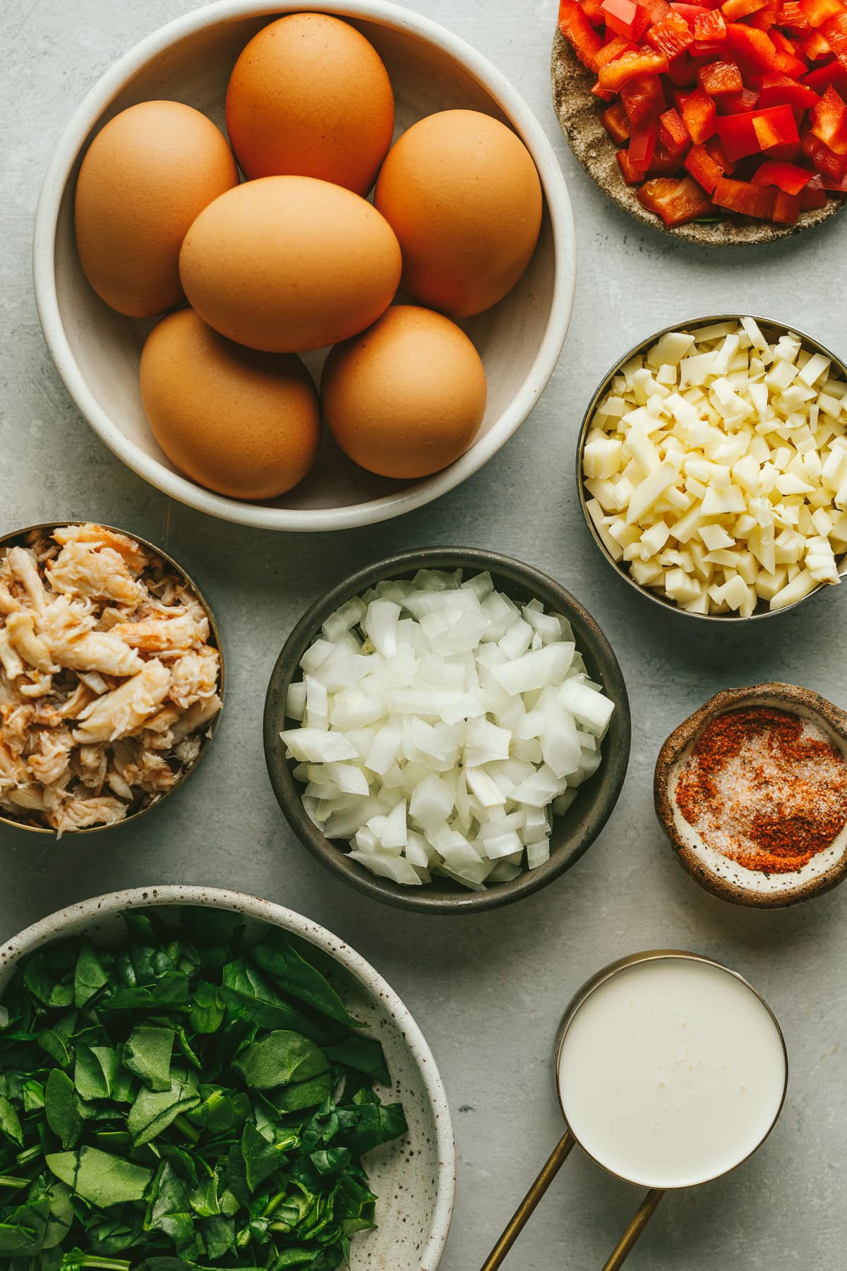 Ingredients for crab frittata on a gray marble surface.