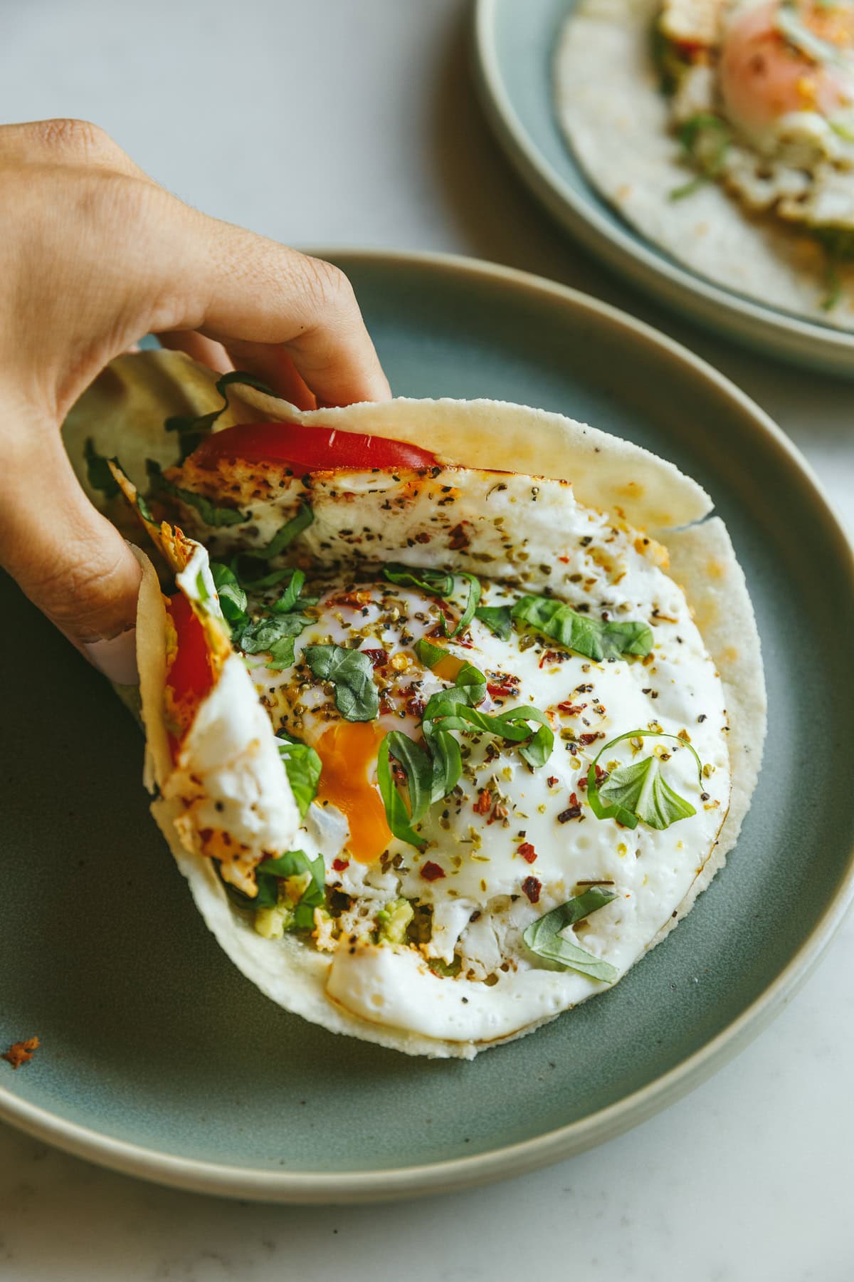 Holding a feta fried egg wrapped in a low-carb tortilla.