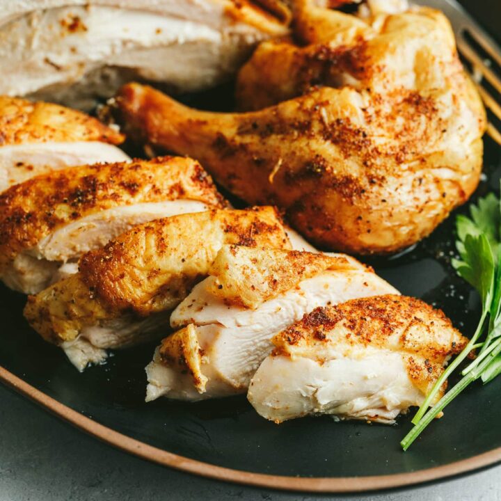 Traeger whole chicken cut into serving pieces on a platter.