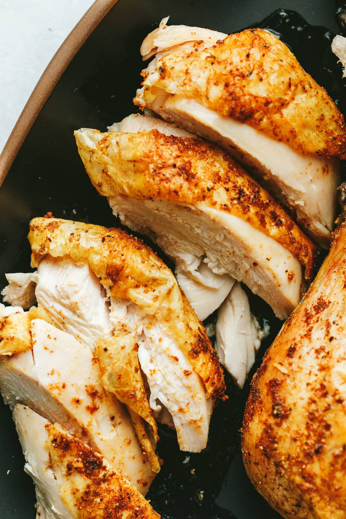 Closeup of carved Traeger whole chicken on a platter.