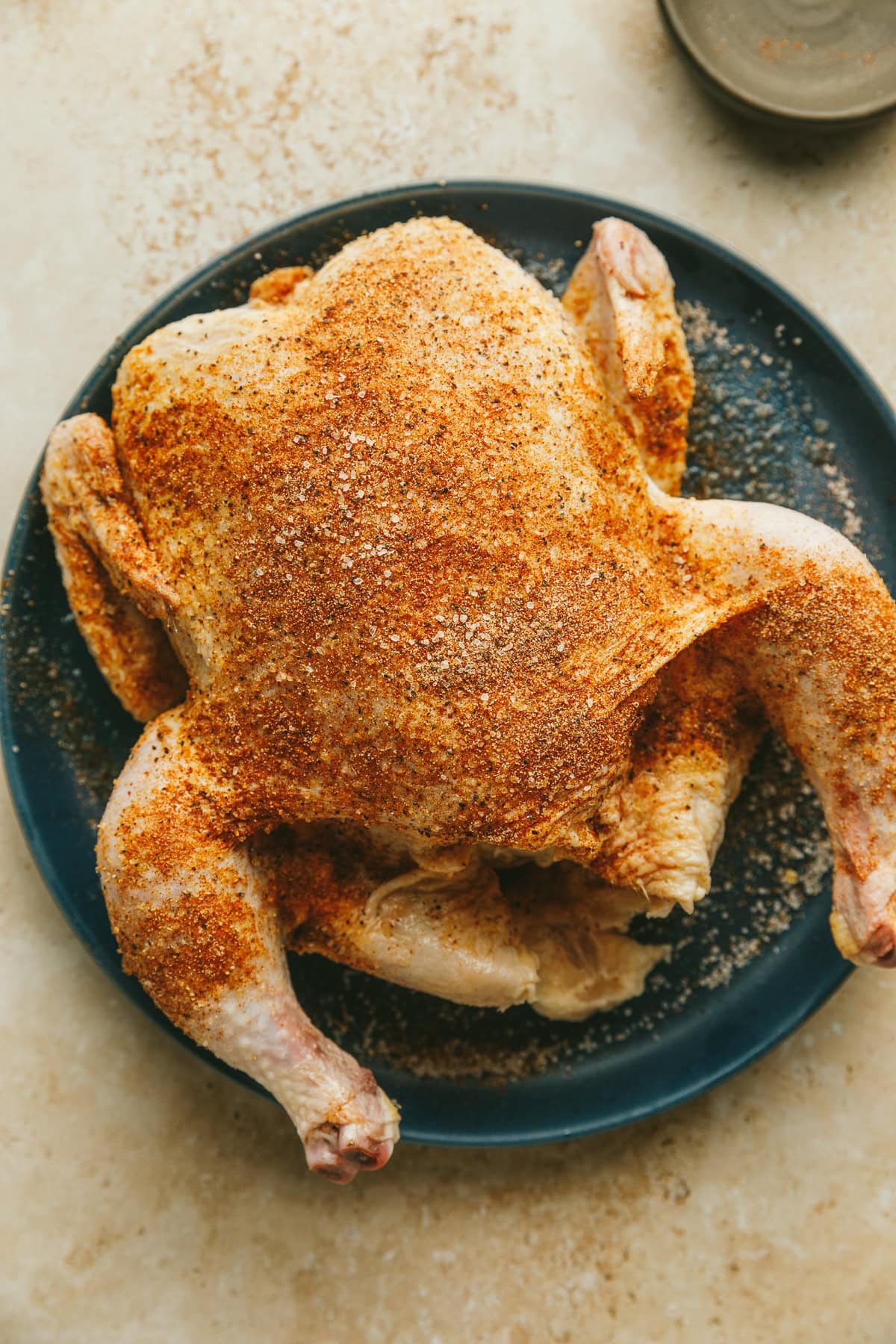 A whole chicken seasoned for the pellet grill.