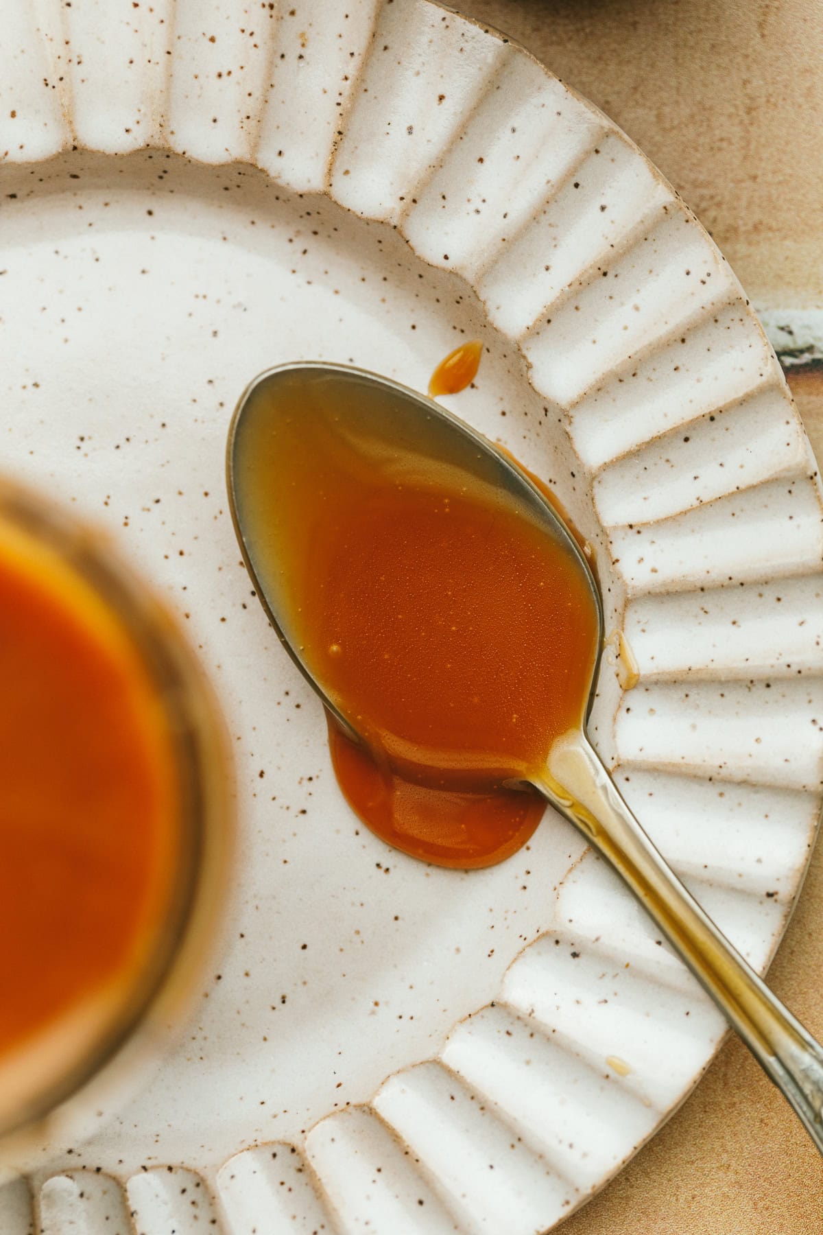 A spoonful of keto caramel sauce on a plate.