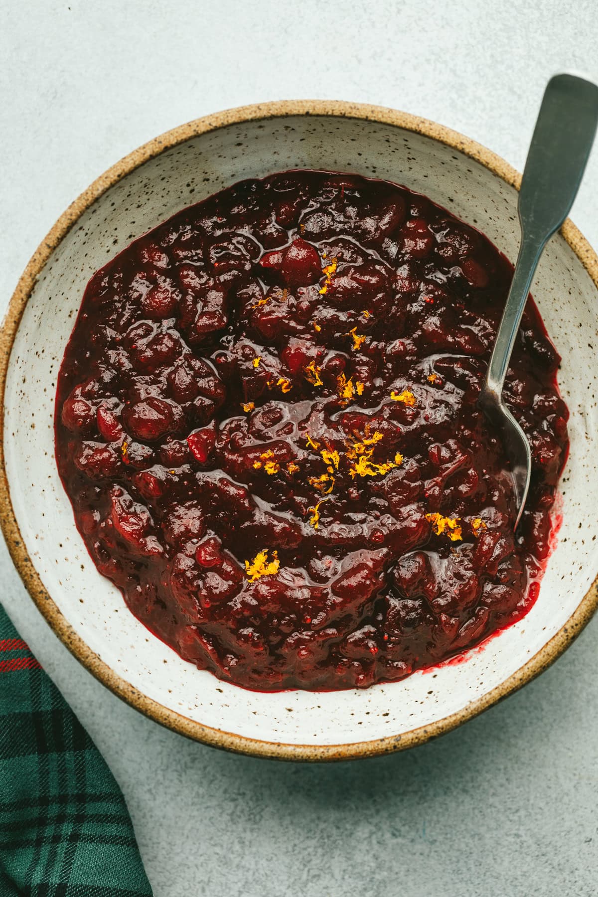 A serving bowl with sugar-free cranberry sauce with a holiday napkin next to it.