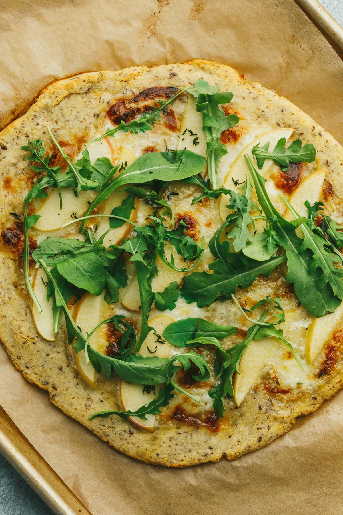 A low-carb flatbread with brie, apple slices and arugula.