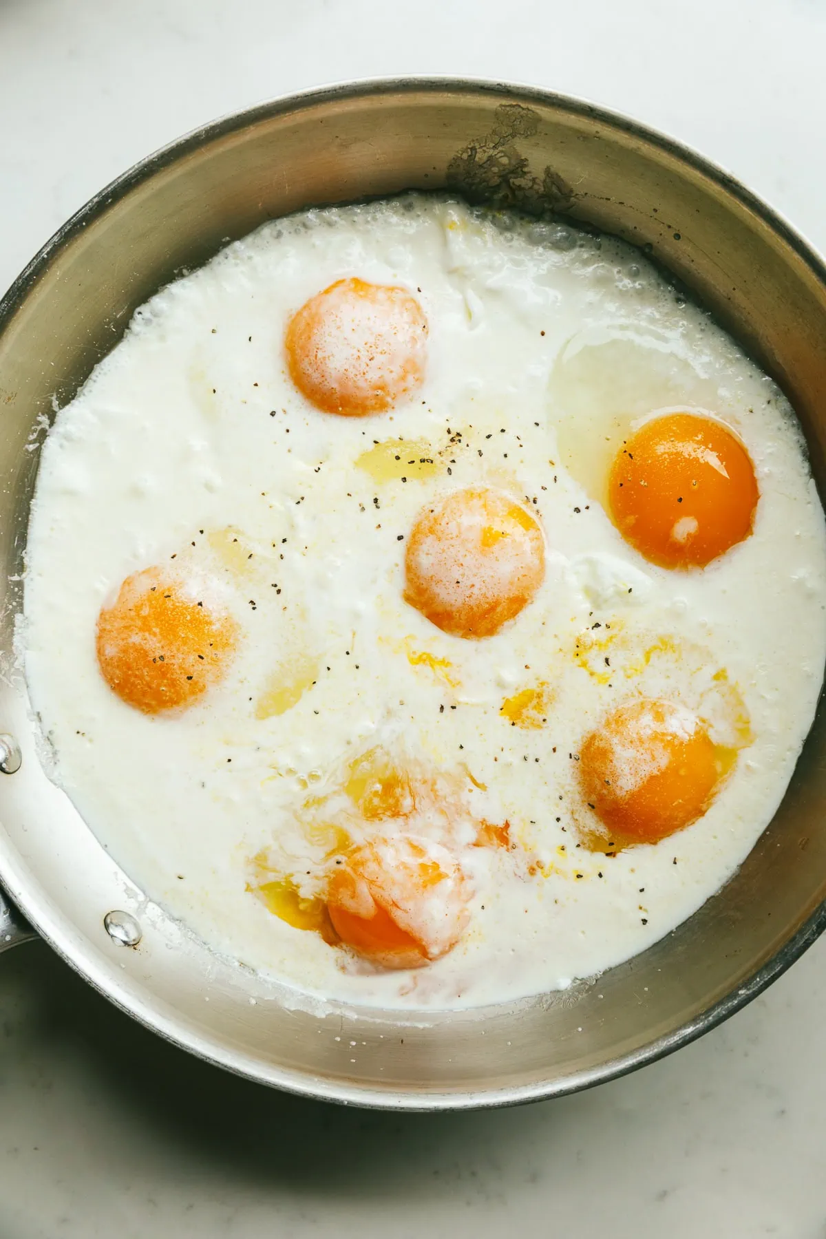 A pan of eggs cooking in cream.