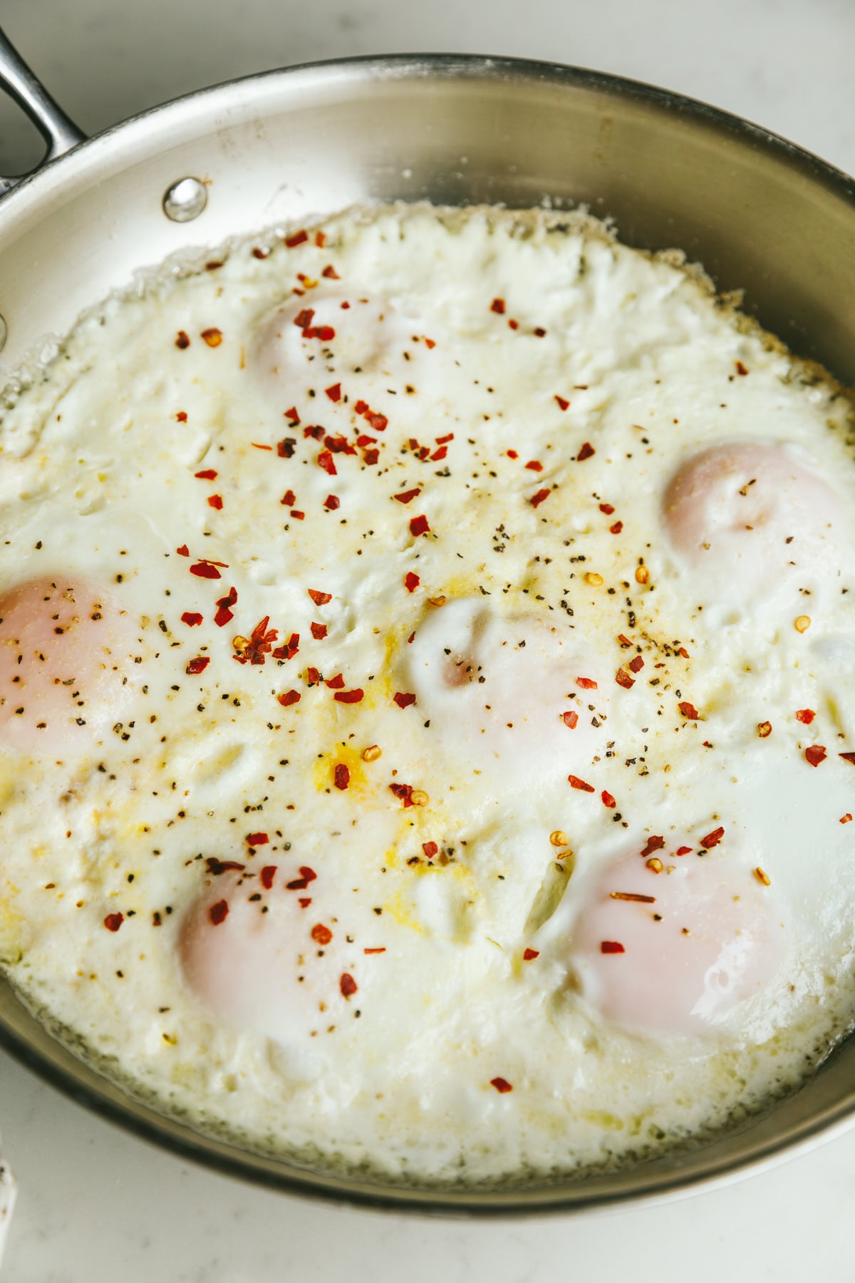 Cooked cream eggs in a stainless steel pan.