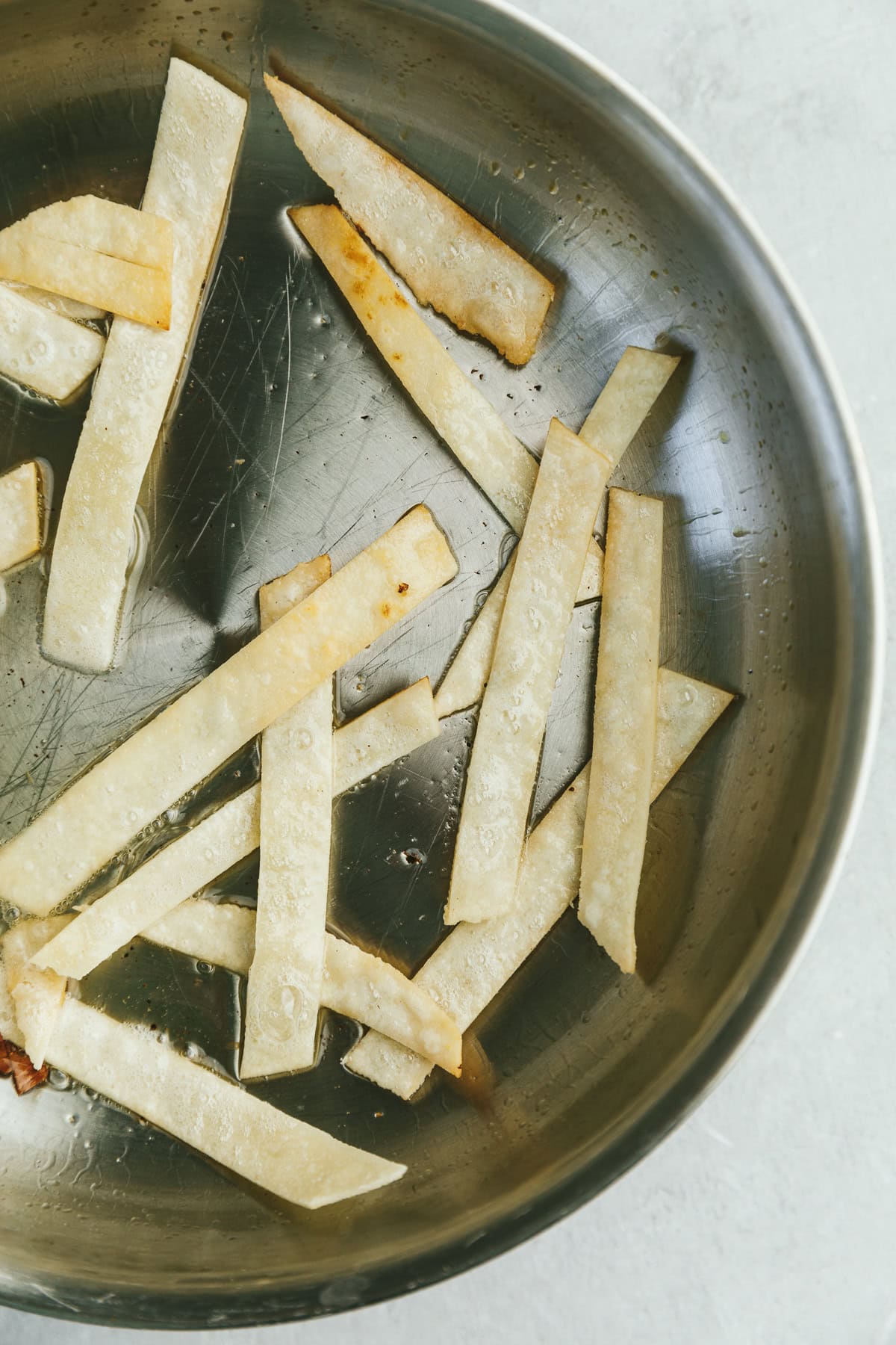 Tortilla strips frying in a pan for keto chicken tortilla soup.
