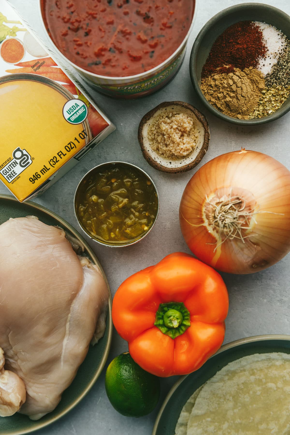 Ingredients for keto chicken tortilla soup on a gray surface. 