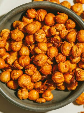 Closeup of crispy air fryer chickpeas in a brown dish.