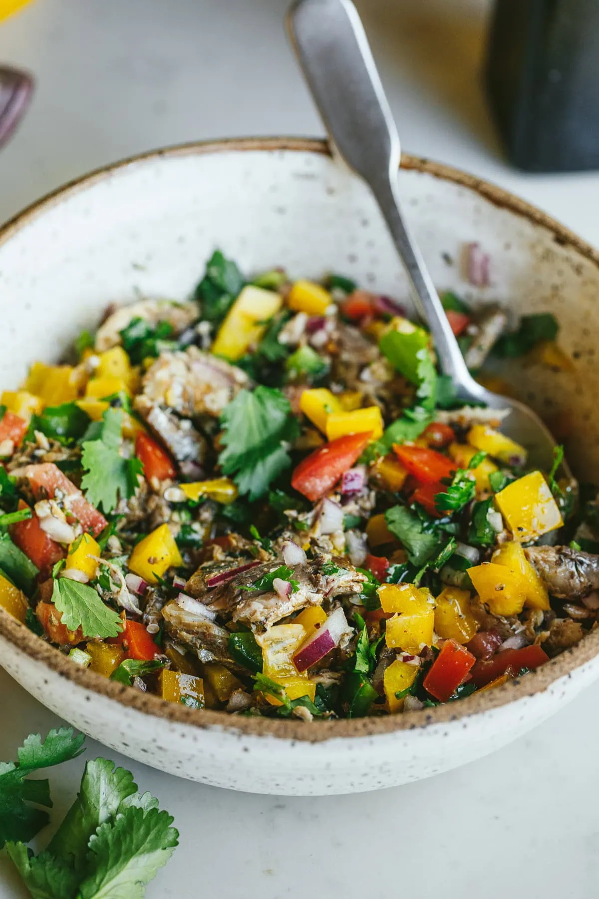 Sardine escabeche in a serving bowl on a white countertop.