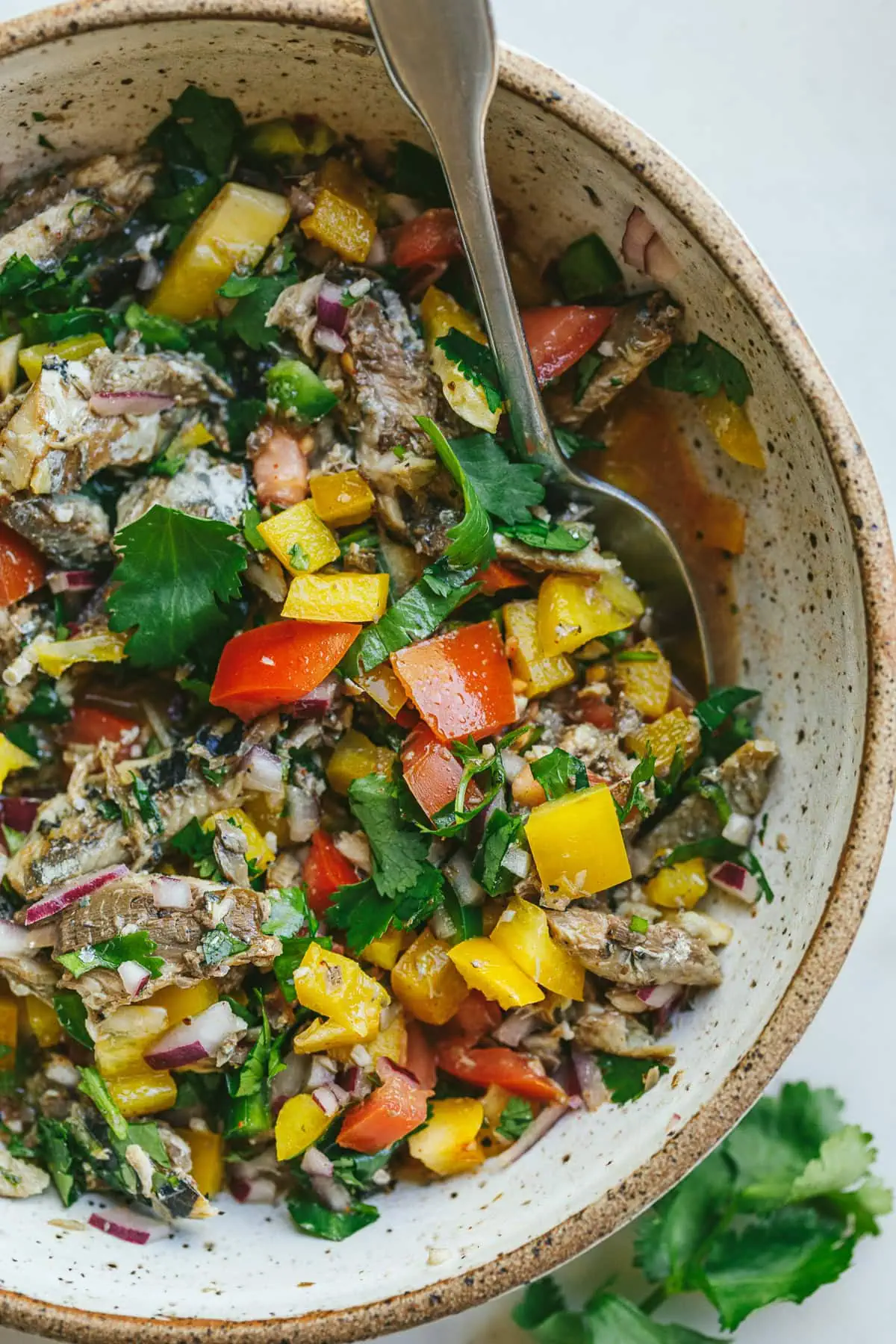 Closeup of sardine escabeche in a bowl.