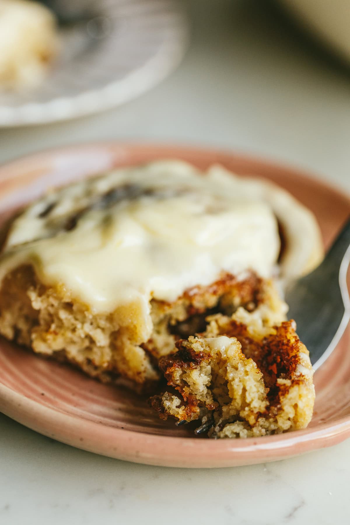 A closeup of a bite of a keto cinnamon roll on a fork.