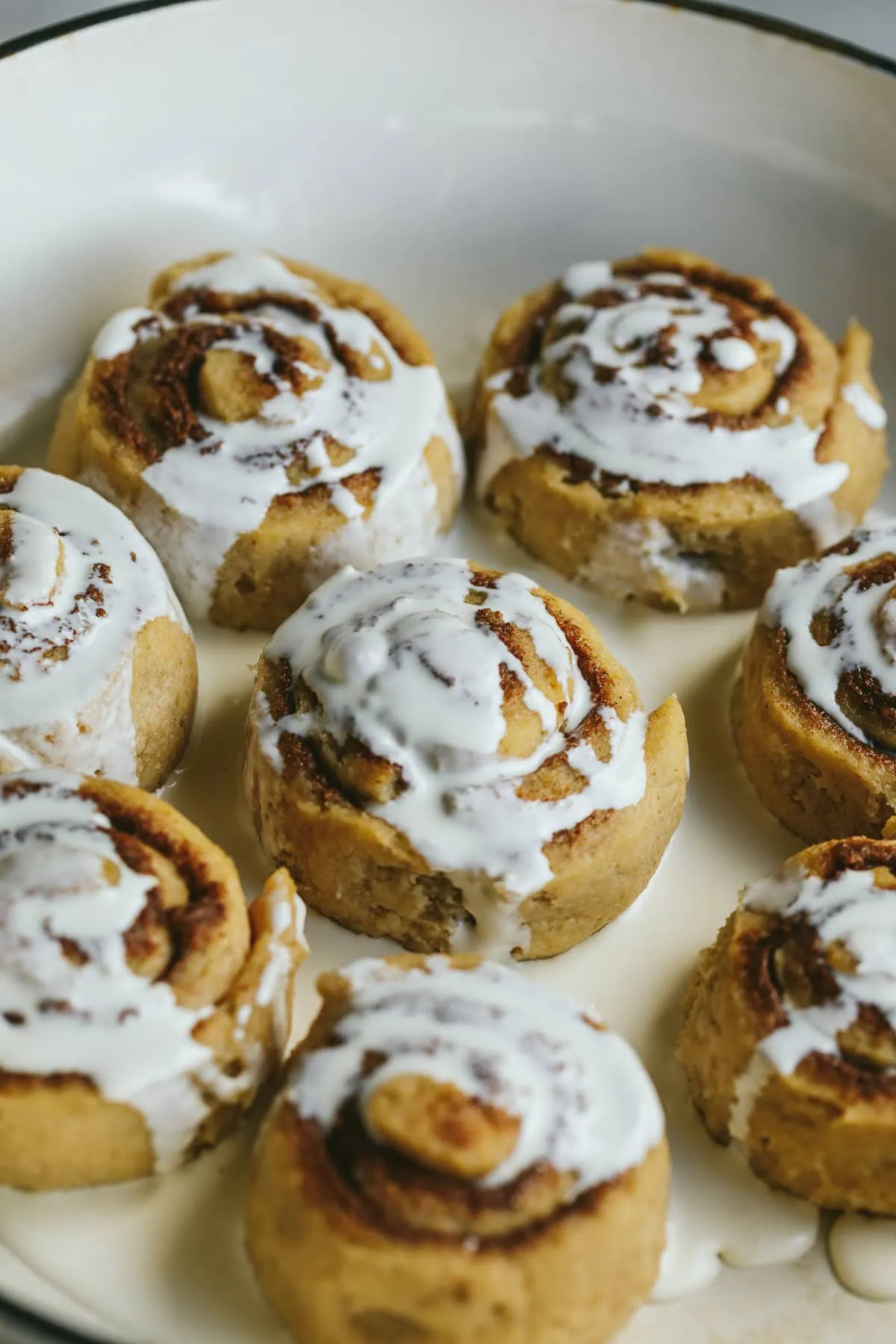 Cream poured onto keto cinnamon rolls before baking.