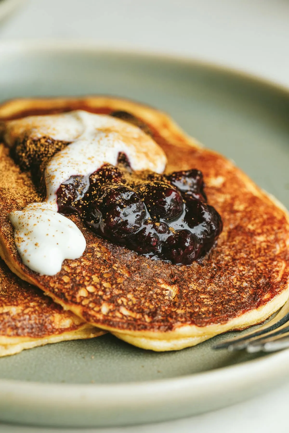 A keto cottage cheese pancake with berry compote on a plate.