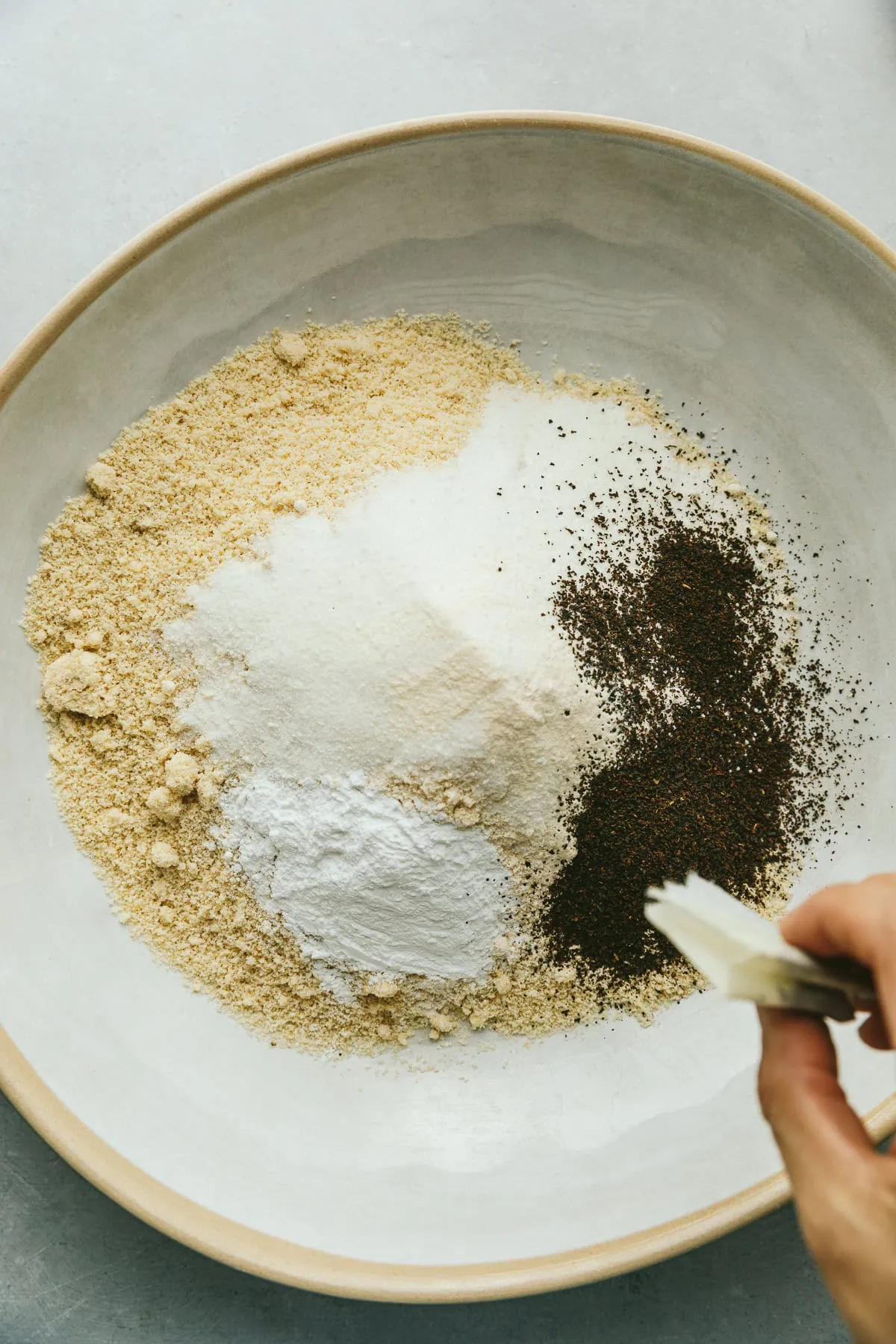 Pouring tea into the dry ingredients in the mixing bowl.