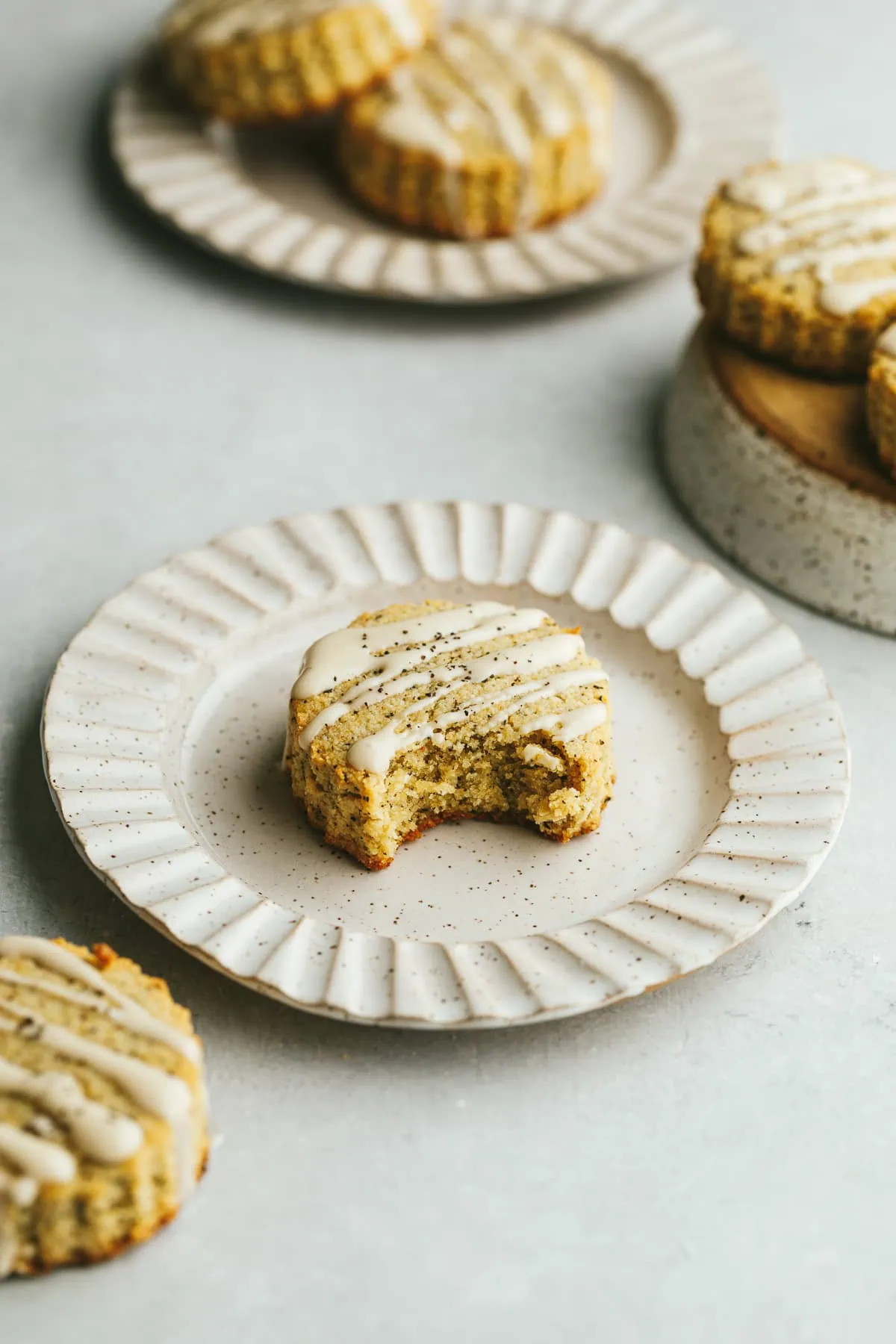 Earl grey scones with vanilla glaze on scalloped plates.