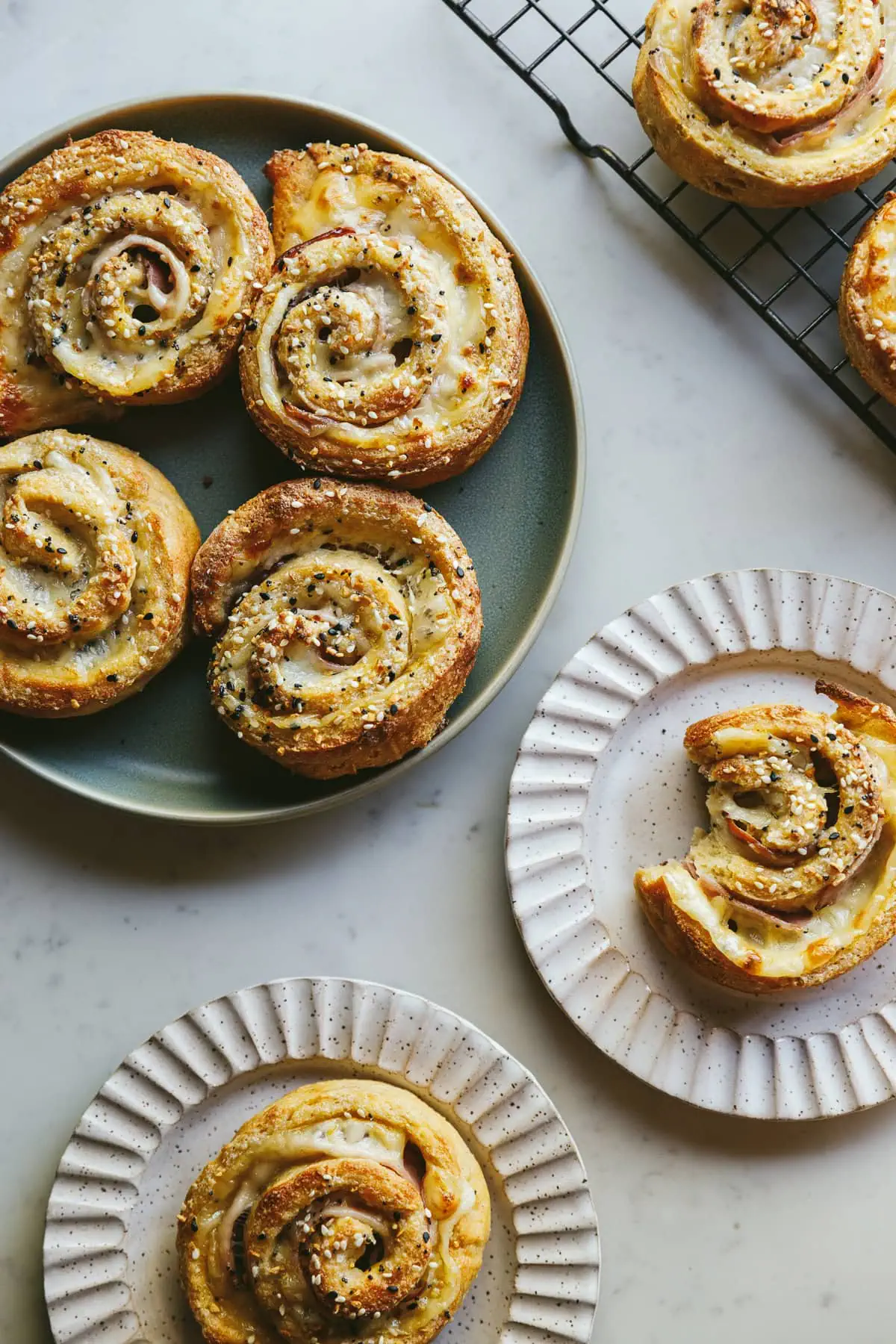 Low-carb pinwheels ready for serving on a green plate and scalloped plates.