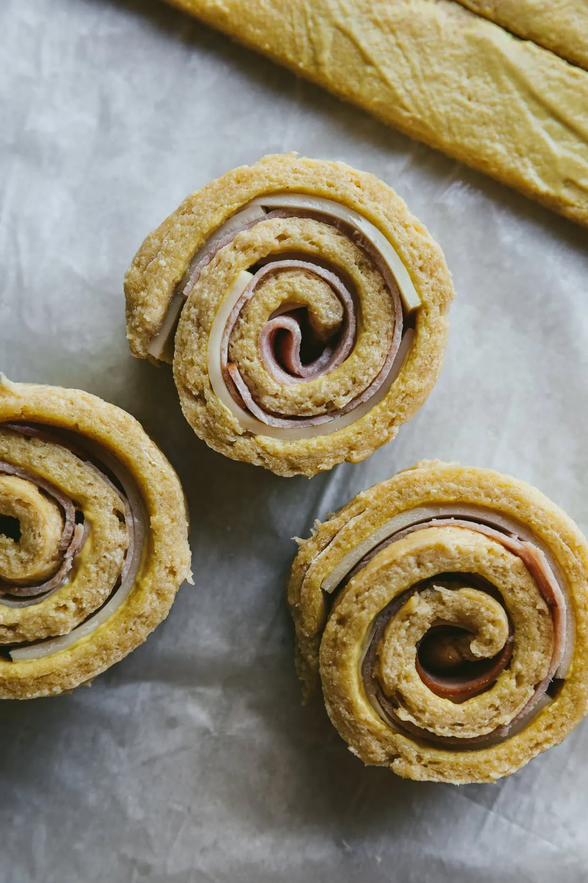 Threw keto pinwheels before baking next to rolled out dough.