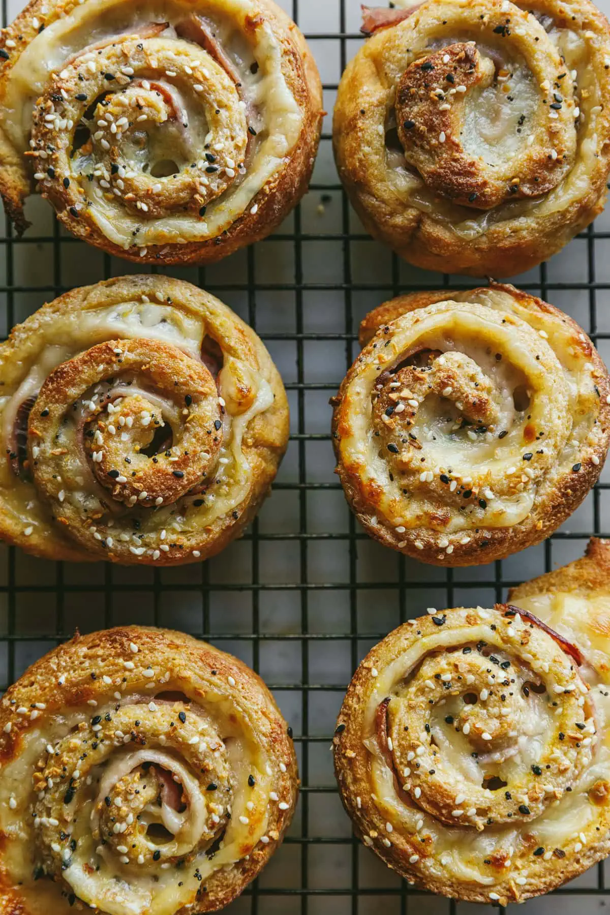 Six baked keto and low-carb pinwheels on a cooling rack.