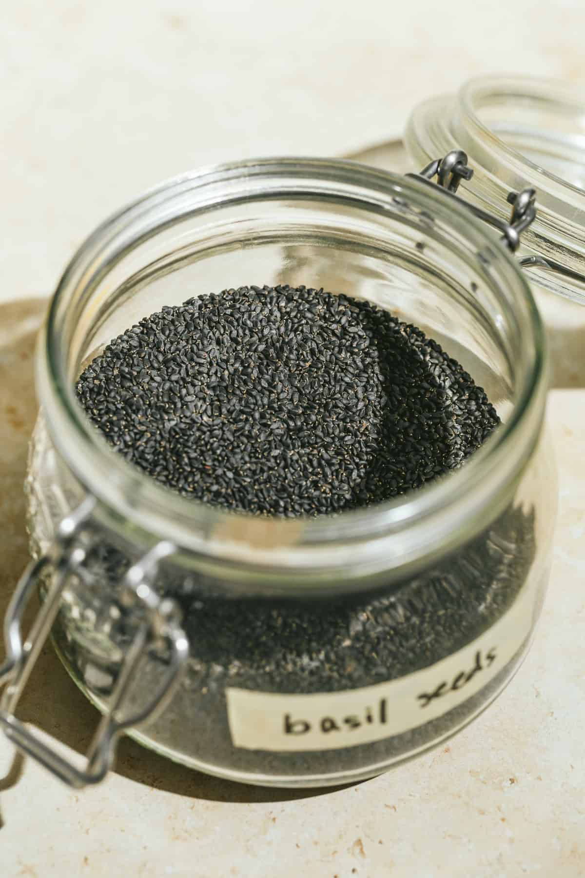 Dry basil seeds in a glass jar.