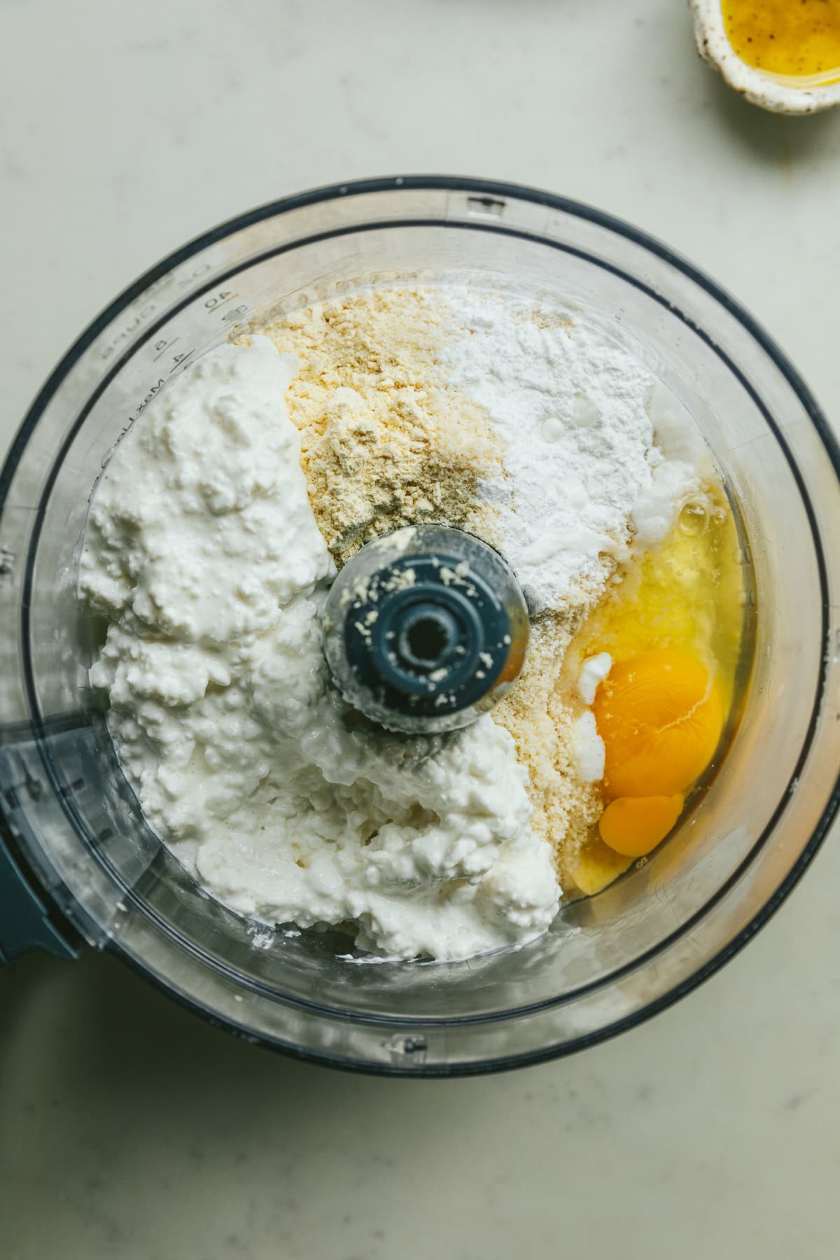 Ingredients for keto cottage cheese pizza crust in a food processor before blending.