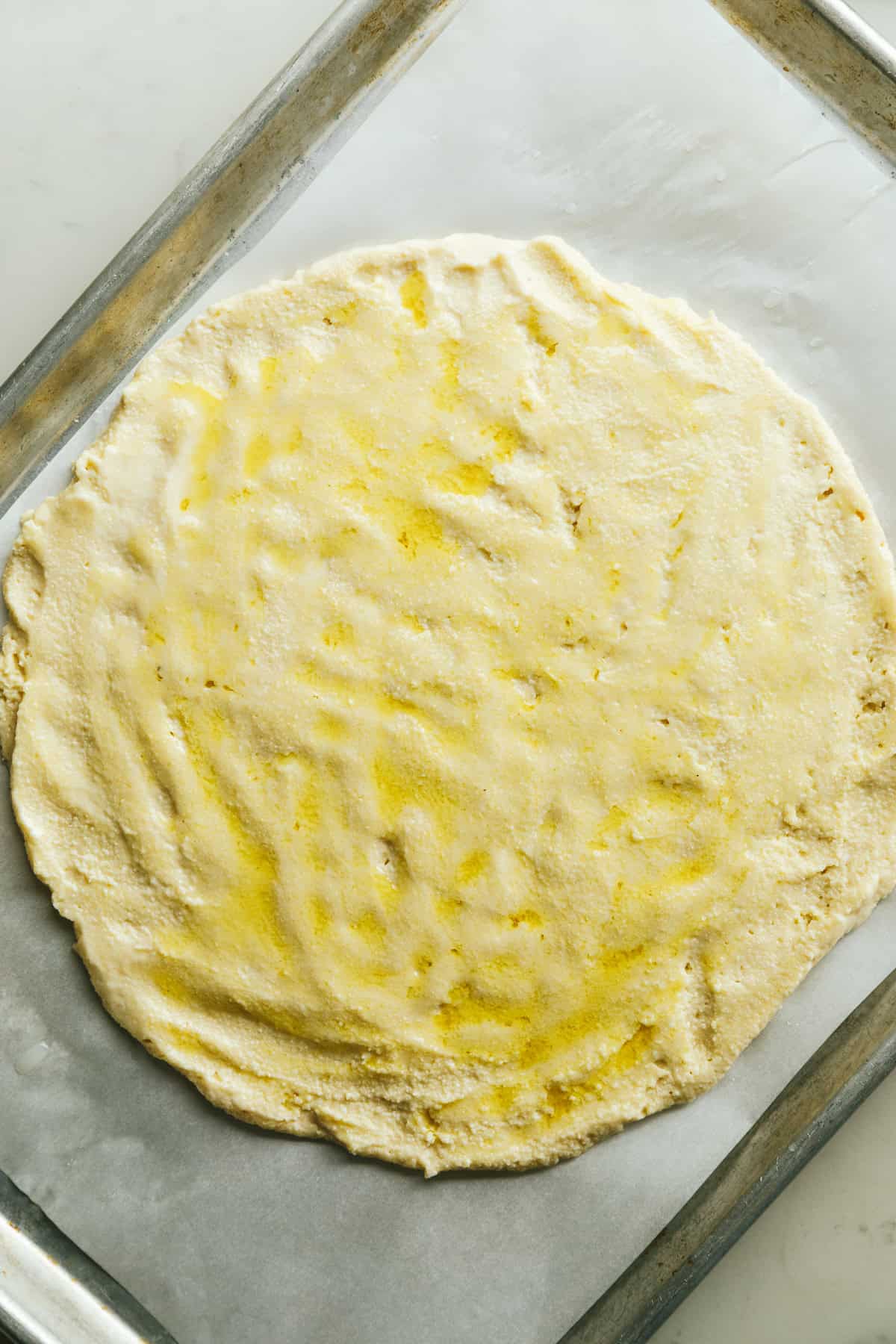 Keto cottage cheese pizza crust on a baking sheet before going into the oven.
