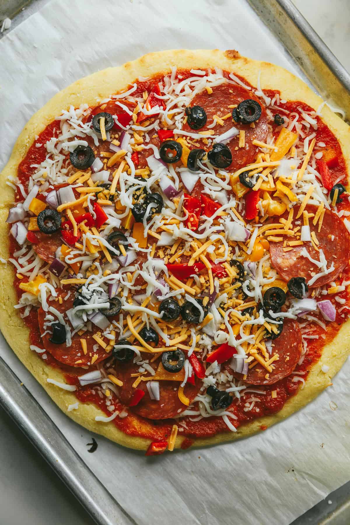 A keto cottage cheese pizza crust with toppings before baking.